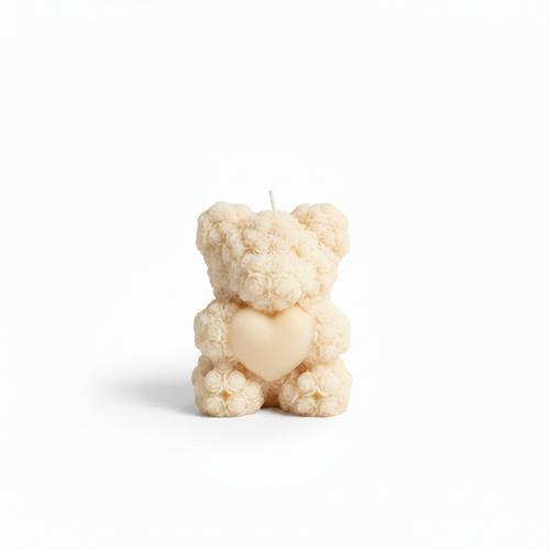 Cream rose-textured teddy bear candle with heart detail on white background