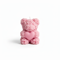 Pink rose-textured teddy bear candle with heart detail on white background